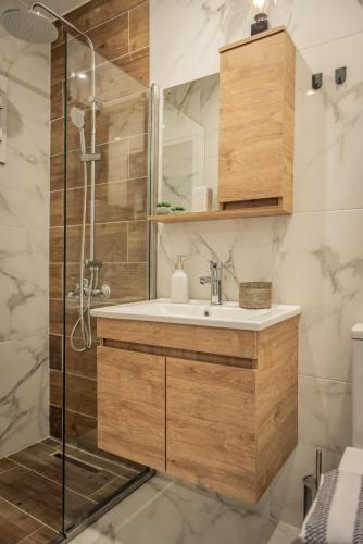 a bathroom with a sink and a shower at Artemis Apartment Midas Home Project in Thessaloniki