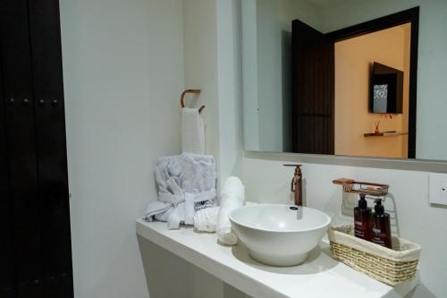 a bathroom with a sink and a mirror and towels at Terra Inn Hotel Boutique in Guaduas