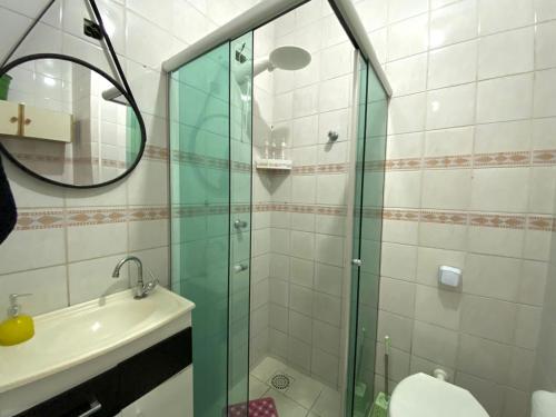 uma casa de banho com uma cabina de duche em vidro e um lavatório. em Apto 604 vibes em Capão da Canoa
