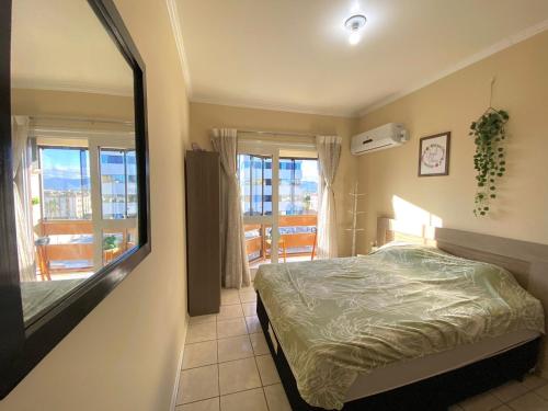 um quarto com uma cama e um espelho grande em Apto 604 vibes em Capão da Canoa