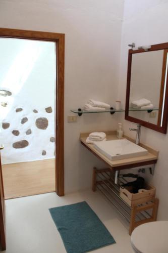 een badkamer met een wastafel en een spiegel bij Casa BellaVista de Haría in Haría