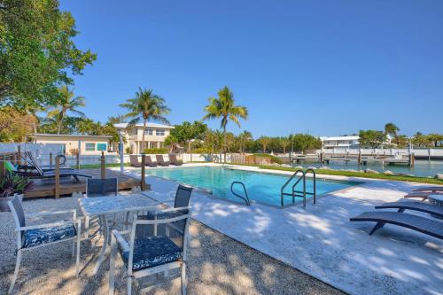 a swimming pool with chairs and a table in front of it at Seascape Resort & Marina in Marathon
