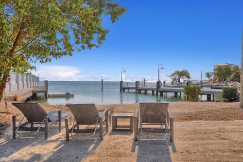 three chairs and a table next to the water at Seascape Resort & Marina in Marathon