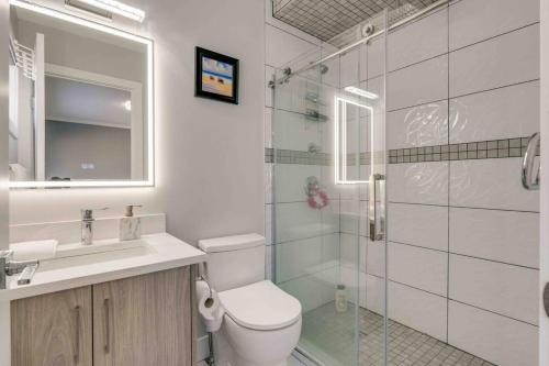 y baño con aseo, lavabo y ducha. en Rare Find fully renovated 6 bedroom 3 bath and both levels, en Calgary