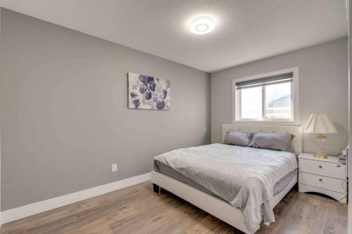 Habitación blanca con cama y ventana en Rare Find fully renovated 6 bedroom 3 bath and both levels, en Calgary