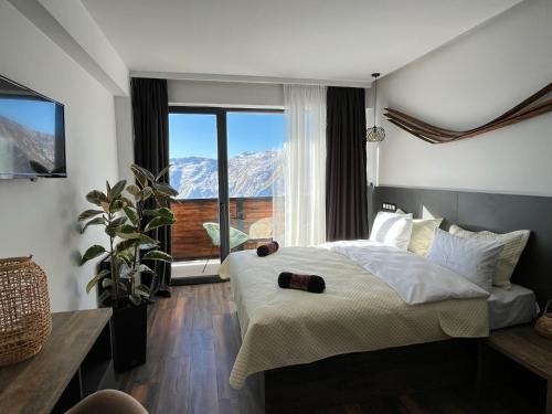 um quarto com uma cama grande e uma janela grande em Luxury hotel room with amazing views em Gudauri