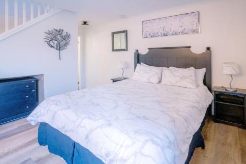 a bedroom with a large bed with white sheets at Loft with a view of Blue - Free Wifi, Linens and Towels Included in Blue Mountains