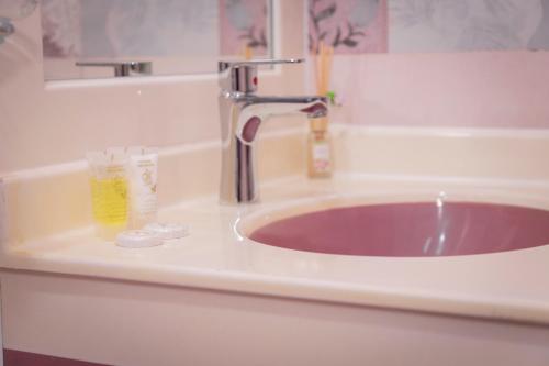 um lavatório numa casa de banho com um lavatório roxo em AL shoroq Green Resort em Ghubrat Ţanūf