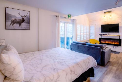 a bedroom with a large bed and a blue couch at Loft with a view of Blue - Free Wifi, Linens and Towels Included in Blue Mountains