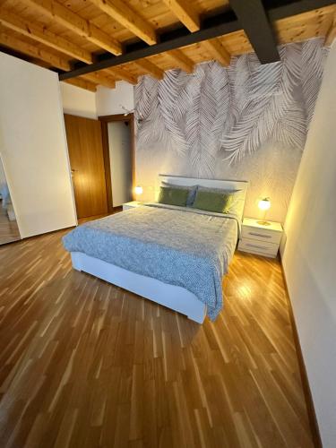 a bedroom with a bed and a wooden floor at Stella / Bergamo center in Bergamo