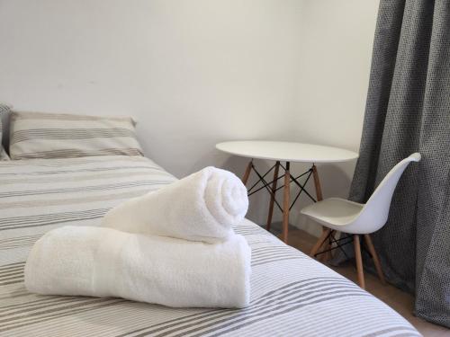 a bed with a pile of white towels on it at East Park Inn in Polokwane