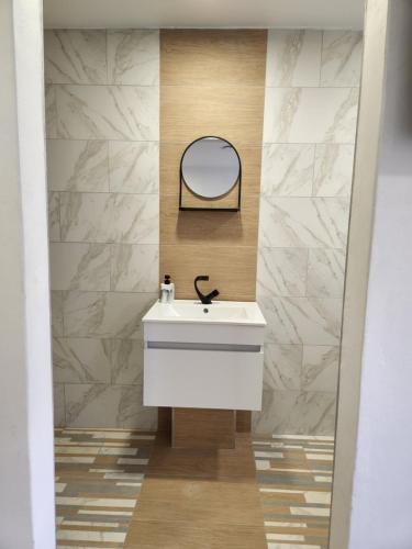 a bathroom with a white sink and a mirror at East Park Inn in Polokwane