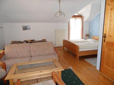 a living room with a couch and a bed at Hotel & Hostel Sandwirt in Bad Ischl