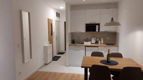 a kitchen with a table with a bottle of wine on it at Apartmani Šišarka in Kopaonik