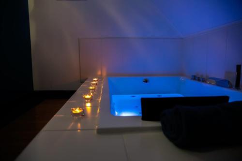 a room with a bath tub with candles in it at Le Wellness Privatif in Seraing