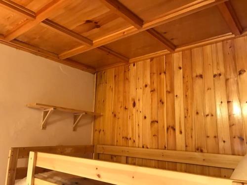 a room with a wooden wall with a bed at Accogliente casa con camino in stile montano in Rovere