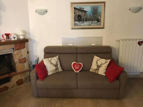 a couch with pillows on it in a living room at Accogliente casa con camino in stile montano in Rovere