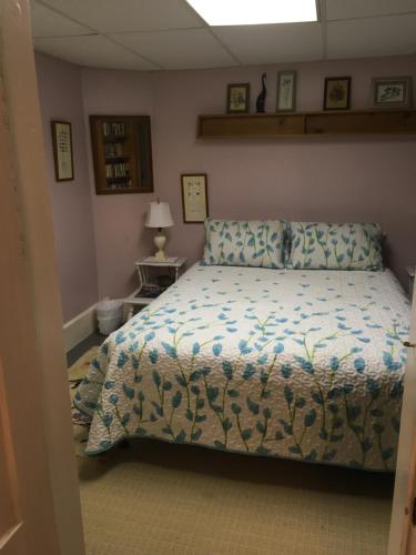 a bedroom with a bed with a comforter at Labyrinthia Guest House in Dexter