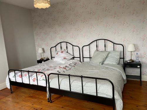 una camera da letto con un letto di metallo e fiori sul muro di Grande maison bourgeoise a Malleval