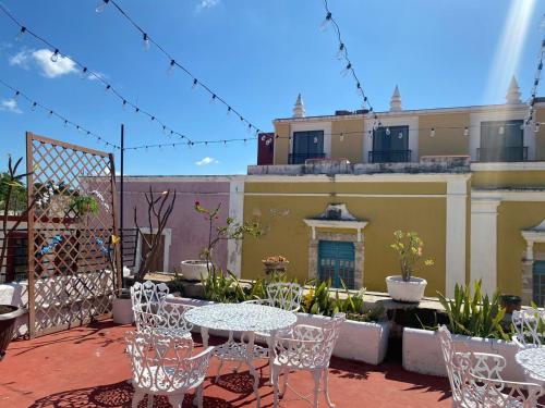 un patio con mesas y sillas en el balcón en Residencial Edzna en Campeche