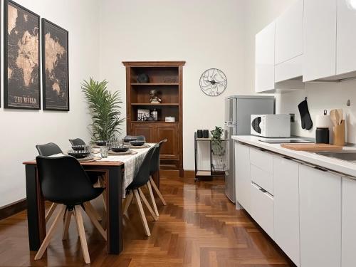 Maison Caesar - Exclusive Apartment [115 m2] في روما: مطبخ مع طاولة وكراسي في مطبخ