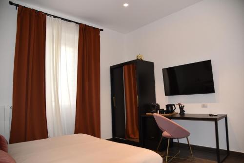 Dormitorio con cama, escritorio y TV en GL rooms and apartments en Bari