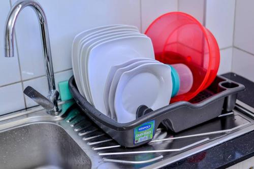 a dishes in a strainer sitting in a sink at Rhezoh Apartment in Nairobi