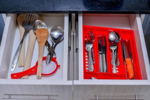 a drawer with utensils in a red tray at Rhezoh Apartment in Nairobi