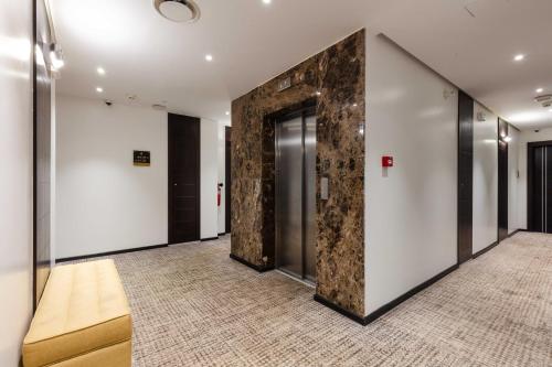 a hallway with a large stone wall in a building at Hotel Best Night 2 in Alger