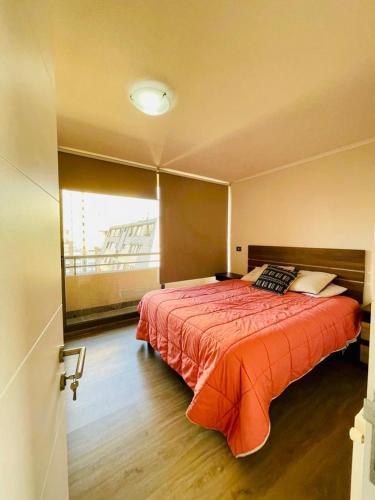 1 dormitorio con 1 cama grande y ventana en Depto en Viña en Viña del Mar