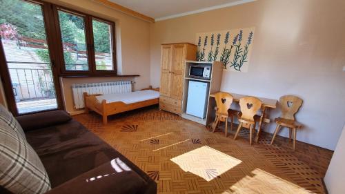 クリニツァ・ズドルイにあるWilla Alpina - Apartamenty Przy Wyciągachのキッチン(テーブル、椅子付)が備わる客室です。