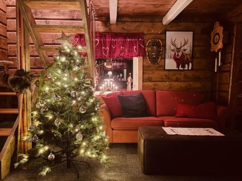 a living room with a christmas tree and a couch at Rauvassgården, romslig, 5 sov, kjøkken, WiFi in Raudvatnet