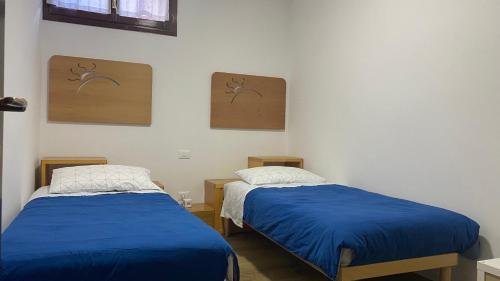 2 letti in una camera con lenzuola blu di Cesa del Sass ad Alba di Canazei