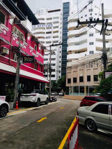 a city street with cars parked in front of buildings at Baipho Lifestyle in Patong Beach