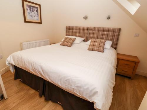 a bedroom with a bed with white sheets and pillows at Tyn-y-Mynydd Bach in Halkyn