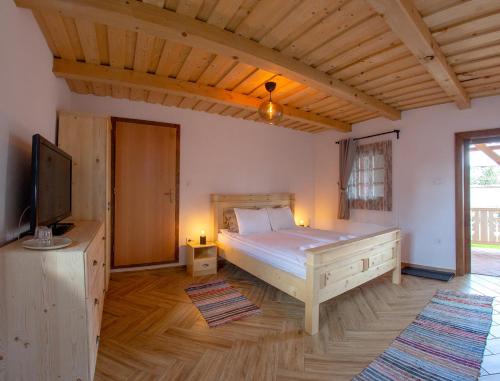a bedroom with a bed and a television in it at Pepi Vendégház - Casa de oaspeți Pepi in Joseni