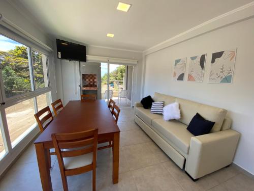 a living room with a table and a couch at Complejo Bosque y Mar in San Clemente del Tuyú