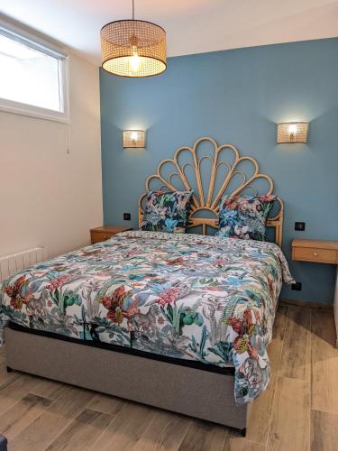 a bedroom with a large bed with a floral bedspread at La Closerie in Droue-sur-Drouette