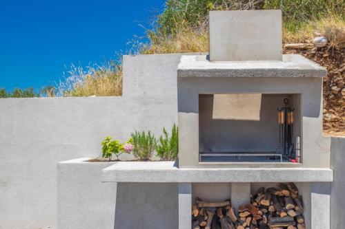 a stone outdoor oven with a pile of fire wood at Luxury Holiday Home Dioniz in Podgora