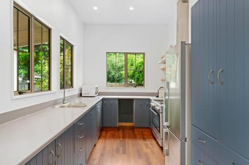 une cuisine avec des comptoirs et des fenêtres bleus et blancs dans l'établissement Gold Rush Cottage - Arrowtown Holiday Home, à Arrowtown