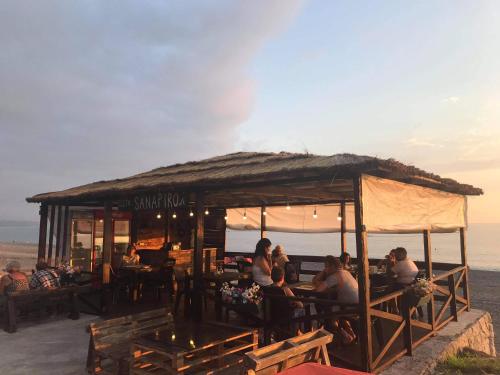 a group of people sitting at a restaurant on the beach at Wave-ტალღა in Kobuleti