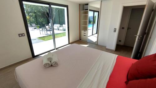 a bedroom with a bed with two slippers on it at VILLA ELA - Jolie villa avec piscine chauffée et jacuzzi in Les Abymes
