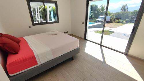 1 dormitorio con cama y vistas a la piscina en VILLA ELA - Jolie villa avec piscine chauffée et jacuzzi, en Les Abymes