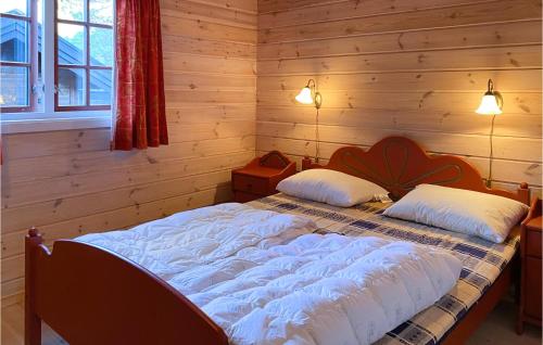 a bedroom with a large bed in a wooden wall at Beautiful Home In Straumgjerde With 3 Bedrooms in Brunstad