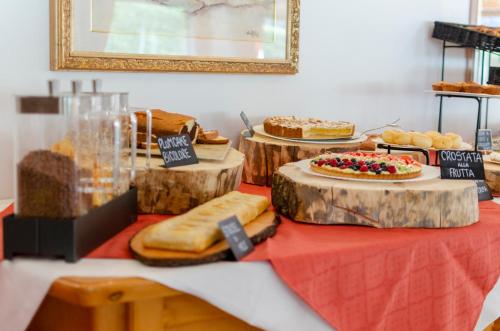 a table topped with lots of different types of bread and cakes at Flos Hotel in Moena