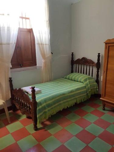 - une chambre avec un lit dans une pièce dotée d'un sol en damier dans l'établissement Casa Bethlen, à Zapatoca