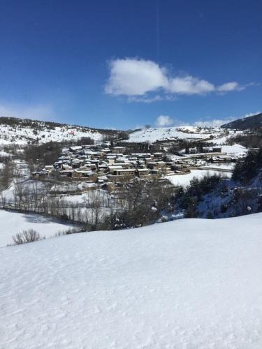 a snow covered field with a town in the distance at Casa Riu in Riu de Cerdanya