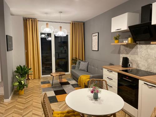 a kitchen and living room with a table and a couch at Capital Towers RZESZOW, free parking, terrace in Rzeszów