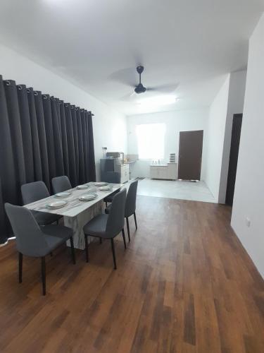 comedor con mesa y sillas en CASARIA HOMESTAY PD 3Bedrooms Bungalow House, en Port Dickson