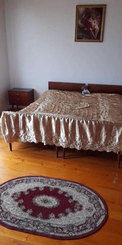 a room with a bed and a rug on a wooden floor at Guest house Enguri in Jvari